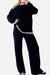 Woman wearing black Chic Contrast Stitch travel set with white stitching on cuffs, neckline, and hem, styled for casual comfort and travel.