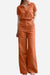 Woman wearing an orange breathable Linen-Look Set with short-sleeve top and wide-leg pants