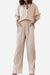 Woman wearing beige professional and smart two-piece set with button-up shirt and wide-leg pants