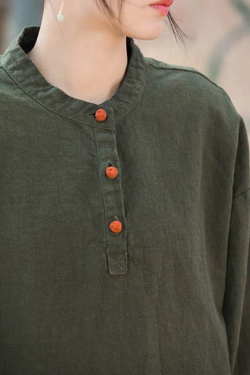 Close-up of woman wearing dark green ramie linen and cotton blouse with orange buttons and mandarin collar
