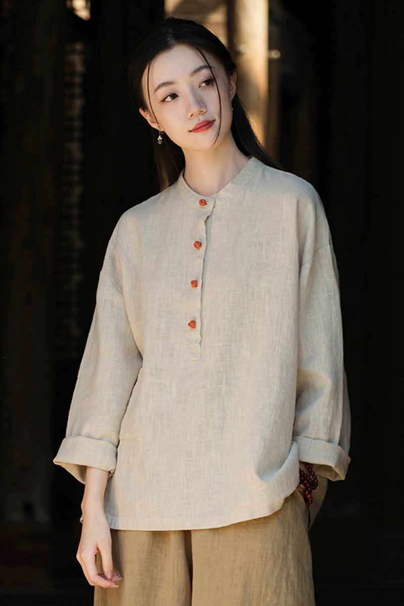 Woman wearing natural beige ramie linen and cotton blouse with long sleeves and wooden buttons