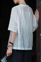 Lightweight white regenerated cellulose blouse with loose fit and short sleeves, wrinkle-resistant and breathable fabric.