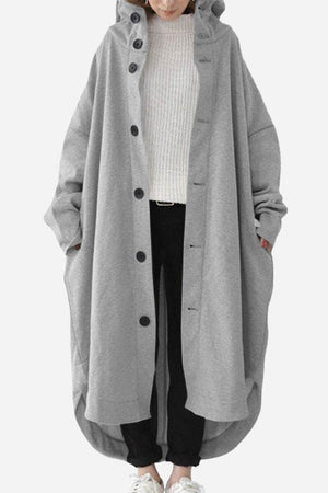 Oversized gray buttoned hooded coat in lightweight breathable fabric with roomy pockets, styled for everyday travel comfort.