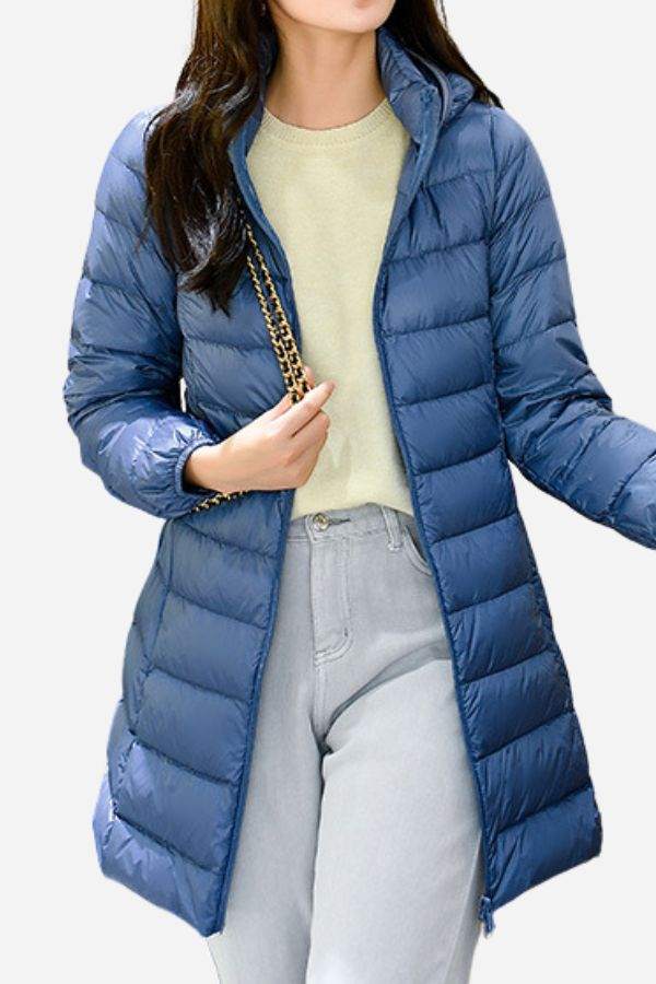 Women wearing lightweight blue water-resistant hooded puffer coat with long sleeves and zip front over casual outfit
