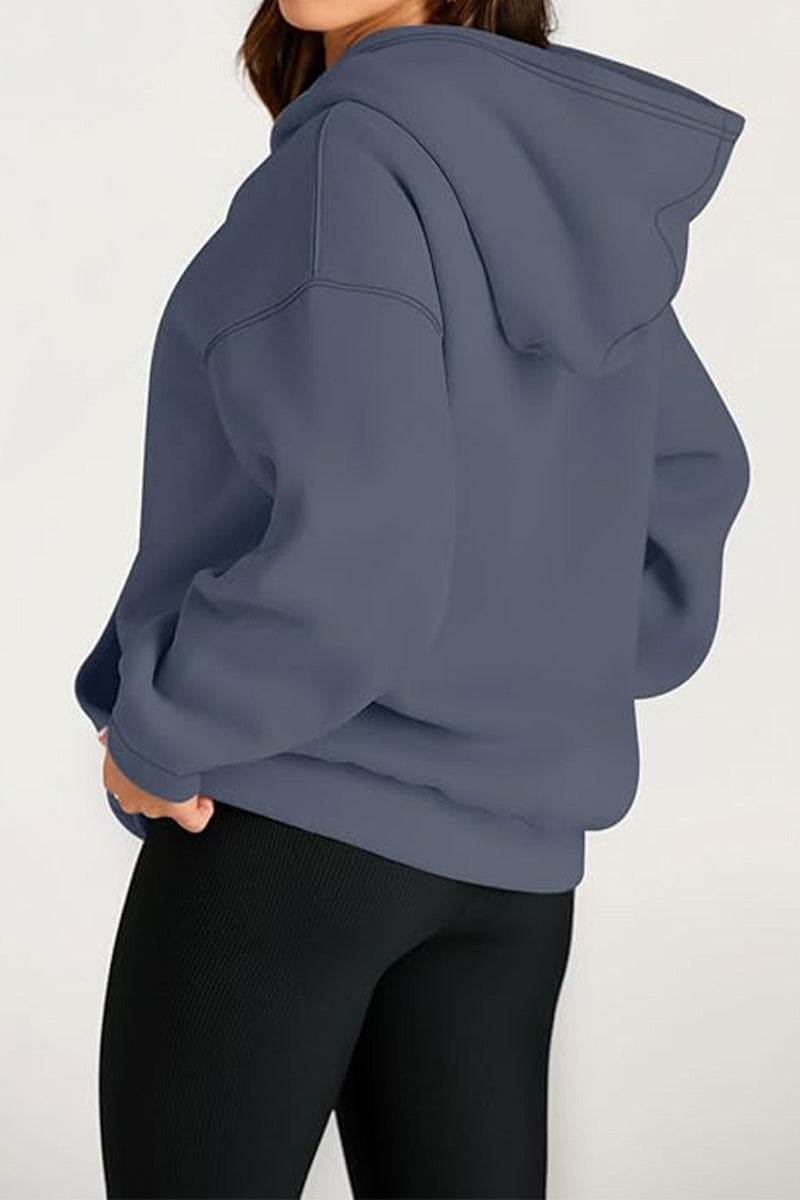 Back view of oversized fleece-lined hoodie in gray worn with black leggings