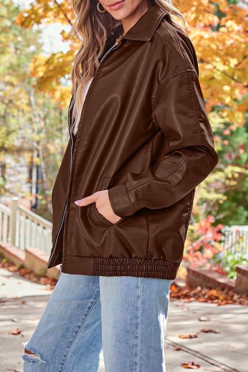 Oversized faux leather brown motorcycle jacket styled with casual jeans in autumn setting