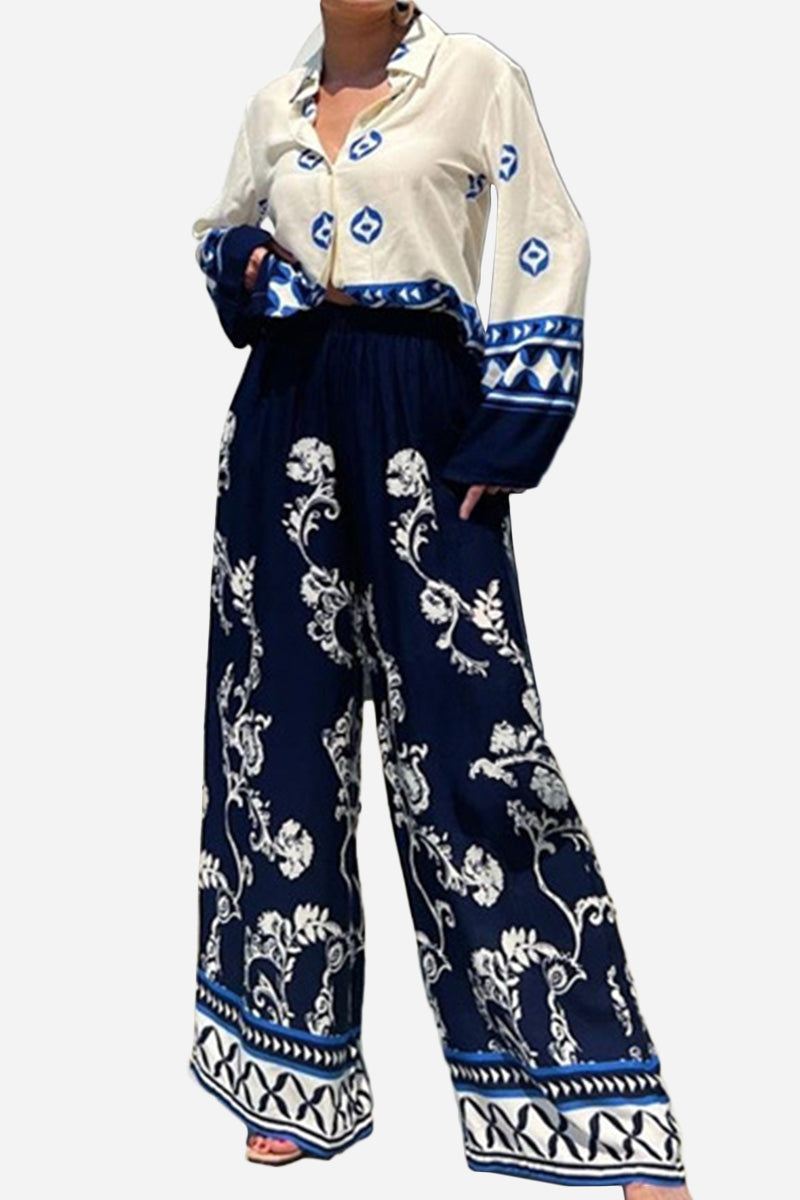 Mediterranean two-piece set with blue and white porcelain-inspired print, featuring a loose white top with blue patterns and flowy navy pants with white floral designs.
