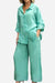 Woman wearing a loose-fitting mint green cotton blend two-piece set with button-up top and wide-leg pants.