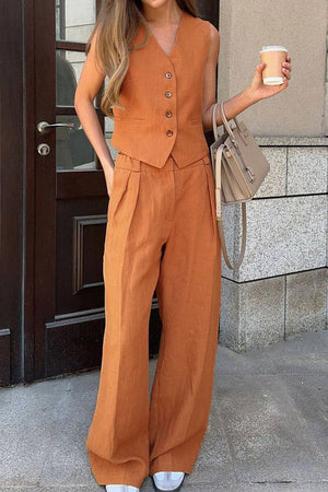woman wearing eco chic linen blend rust-colored two-piece vest and wide-leg pants outfit holding coffee cup and beige handbag outdoors