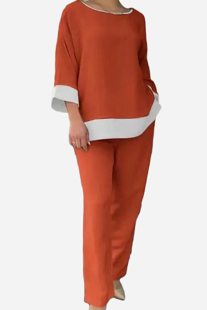 Woman wearing a dual-tone 3/4 sleeve orange and white two-piece set with relaxed fit pants and top.