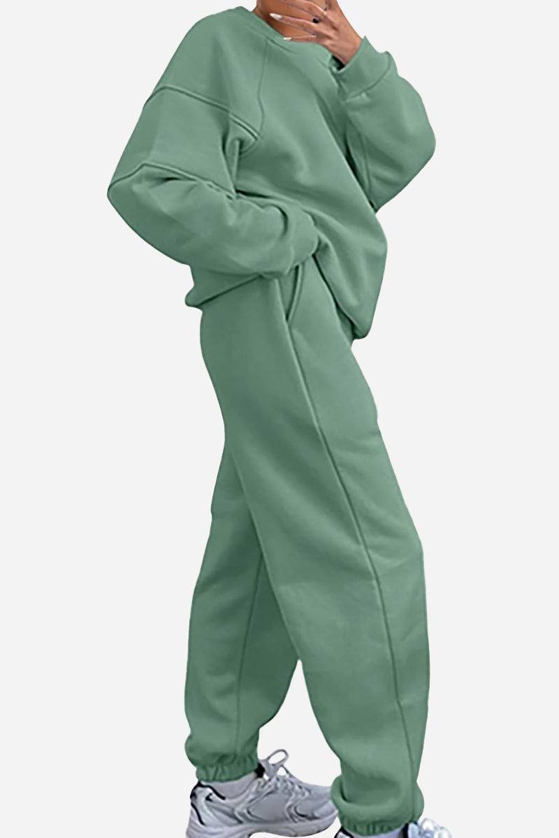 Woman wearing sage green comfy chic tracksuit with relaxed fit and elastic cuffs paired with sneakers