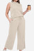 Beige cotton chic sleeveless two-piece set with relaxed fit, drawstring pants, and pockets, styled for casual comfort and travel.