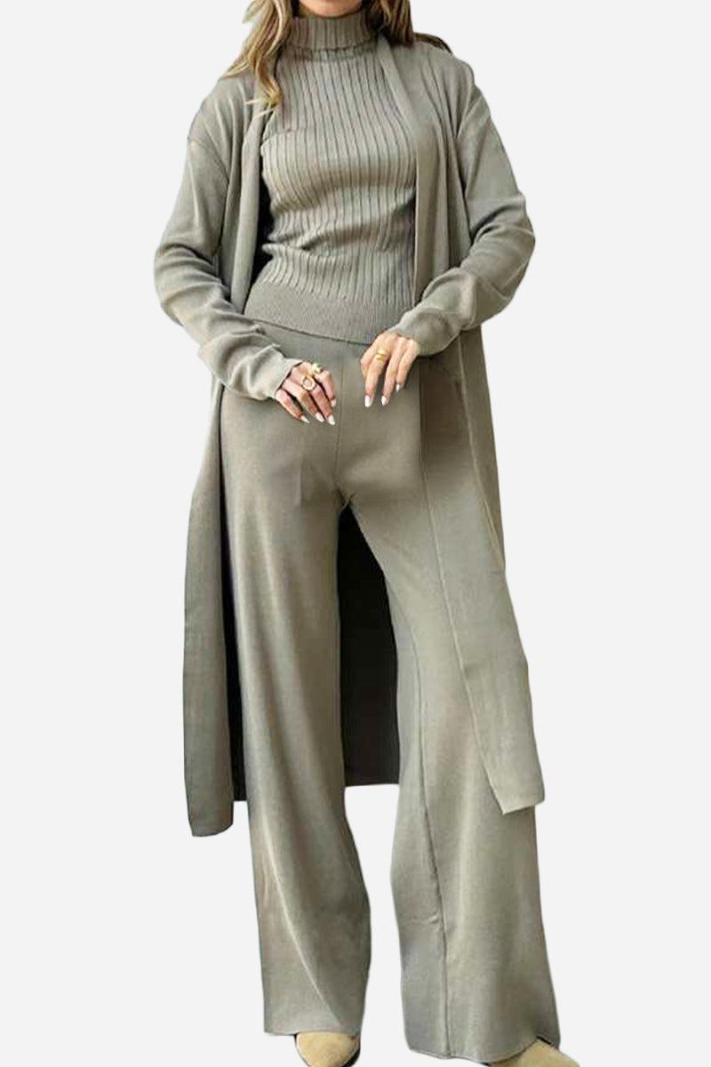 Woman wearing a one-size-fits-all premium three-piece collection in soft, breathable fabric with a long cardigan, ribbed turtleneck top, and wide-leg pants in neutral beige tone