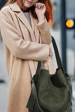 woman carrying vintage charm bag in suede with dual-length straps and spacious design