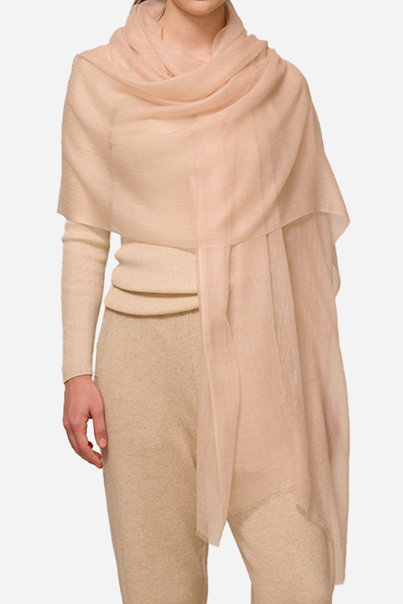 Lightweight 100% cashmere featherlight luxury scarf in soft beige draped over a model's shoulders