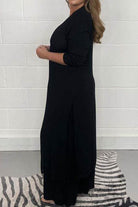 Woman wearing black Urban Chic V-Neck Split Top two-piece set with long sleeves and flowing fit