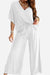 Woman wearing elegant white two-piece pantsuit with V-neck top and wide-leg pants