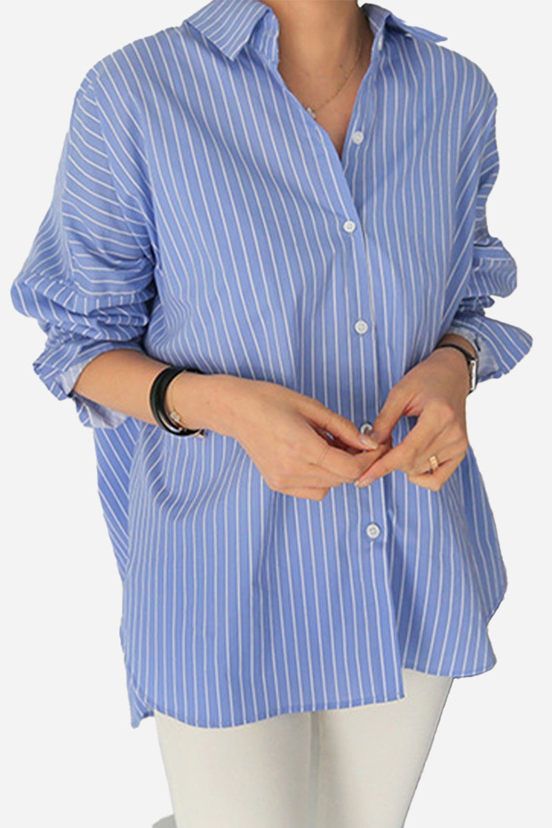 Woman wearing blue and white striped 100% cotton oversized shirt with rolled-up sleeves and white pants