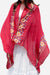 Lightweight red embroidered travel shawl with floral details draped over a white dress