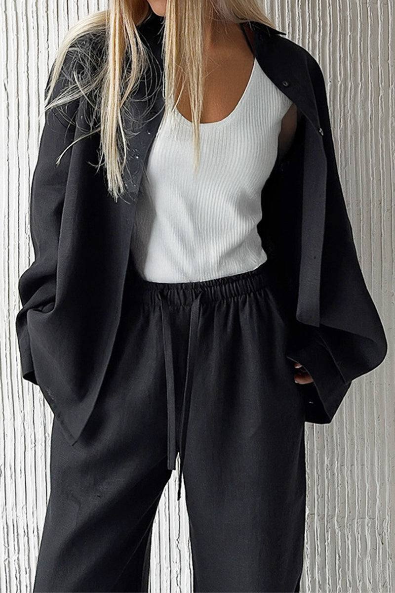 Woman wearing black 100% cotton Wanderlust two-piece set with white tank top.