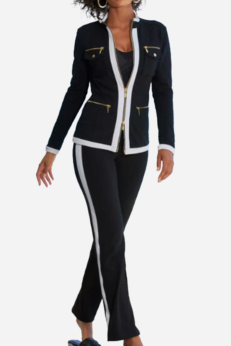 Woman wearing a black sleek contrast zip two-piece outfit with white trim and gold zipper details.