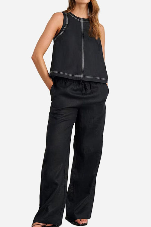 Woman wearing black cotton-linen relaxed back-slit two-piece set with wide-leg trousers and sleeveless top with contrast stitching.