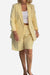 Woman wearing stylish blazer and shorts two-piece set in light yellow with white top and belt.
