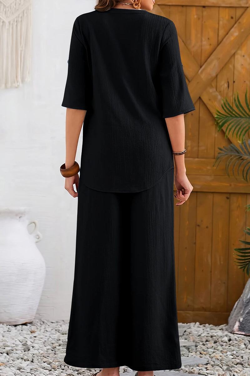 Woman wearing black wrinkle-free wide leg pants and relaxed top set, casual travel outfit.