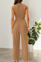 Back view of woman wearing brown Stroll & Hangout Ribbed Knit two-piece set with sleeveless top and wide-leg pants indoors near plant