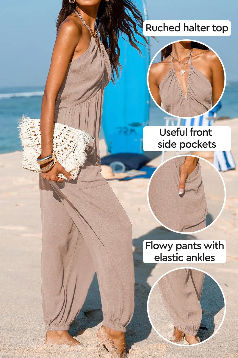 Woman wearing Sunshine On Sand ruched halter-neck jumpsuit with flowy pants and elastic ankle cuffs on beach