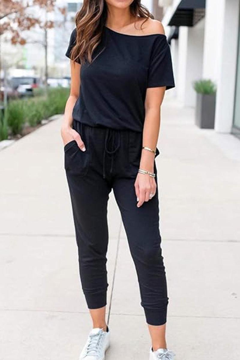Woman wearing black Moonlit Rome Off-Shoulder jumpsuit with pockets and tapered legs outdoors