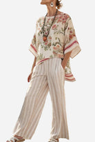 woman wearing Coastal Comfort Linen two-piece set with floral top and striped wide-leg pants