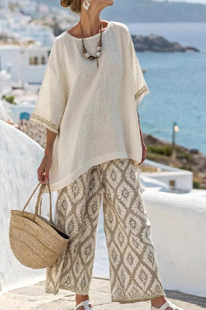 Santorini Sunset Striped two-piece set with loose white top and patterned wide-leg pants by the sea