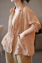 Woman wearing relaxed fit peach linen jacket shirt with notched lapel collar and large front pockets