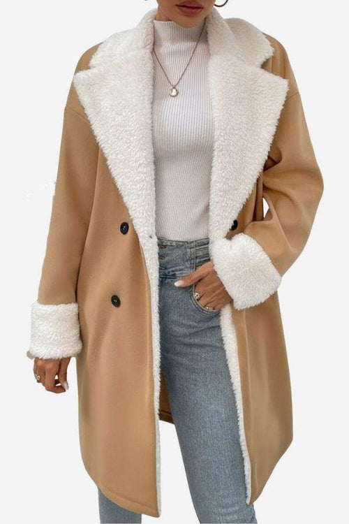 Women wearing Nordic Warmth shearling-lined camel coat with white faux shearling trim and double-breasted buttons over white turtleneck and jeans