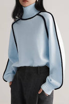 Light blue Zero Itch Turtleneck Sweater with black contrast trim, soft knit, and relaxed modern fit.