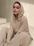 woman wearing beige waffle-knit two-piece hoodie and pants lounge set sitting indoors