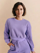 Woman wearing purple 100% cotton waffle knit set with long sleeves and high-waisted pants with drawstring.