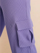 Close-up of purple cotton waffle knit fabric pants with side cargo pocket detail