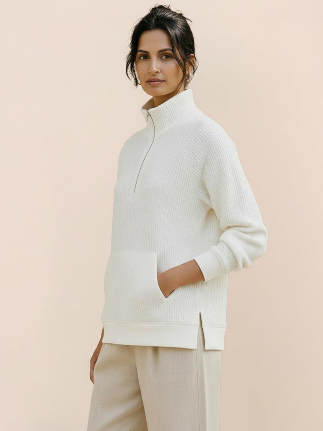 Half-zip waffle pullover with fold-over collar and front kangaroo pocket in neutral tones.