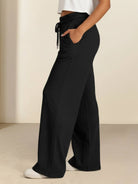 Soft knit wide-leg pants in breathable fabric with elastic drawstring waist and side pockets for comfortable everyday wear