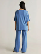 Woman wearing oversized long-line loungewear set with pullover and wide-leg pants