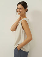 cotton-linen sleeveless top with round neckline and button closure, relaxed A-line silhouette, hip-length design for tucking or loose wear