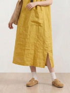 Woman wearing 100% linen relaxed midi pocket dress with short sleeves and side slits
