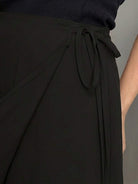 woman wearing asymmetrical wrap maxi skirt with side tie and flowing asymmetric hem