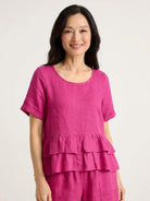 Woman wearing navy blue cotton relaxed shorts and matching short sleeve top with ruffle hem detail in a two-piece co-ord set
