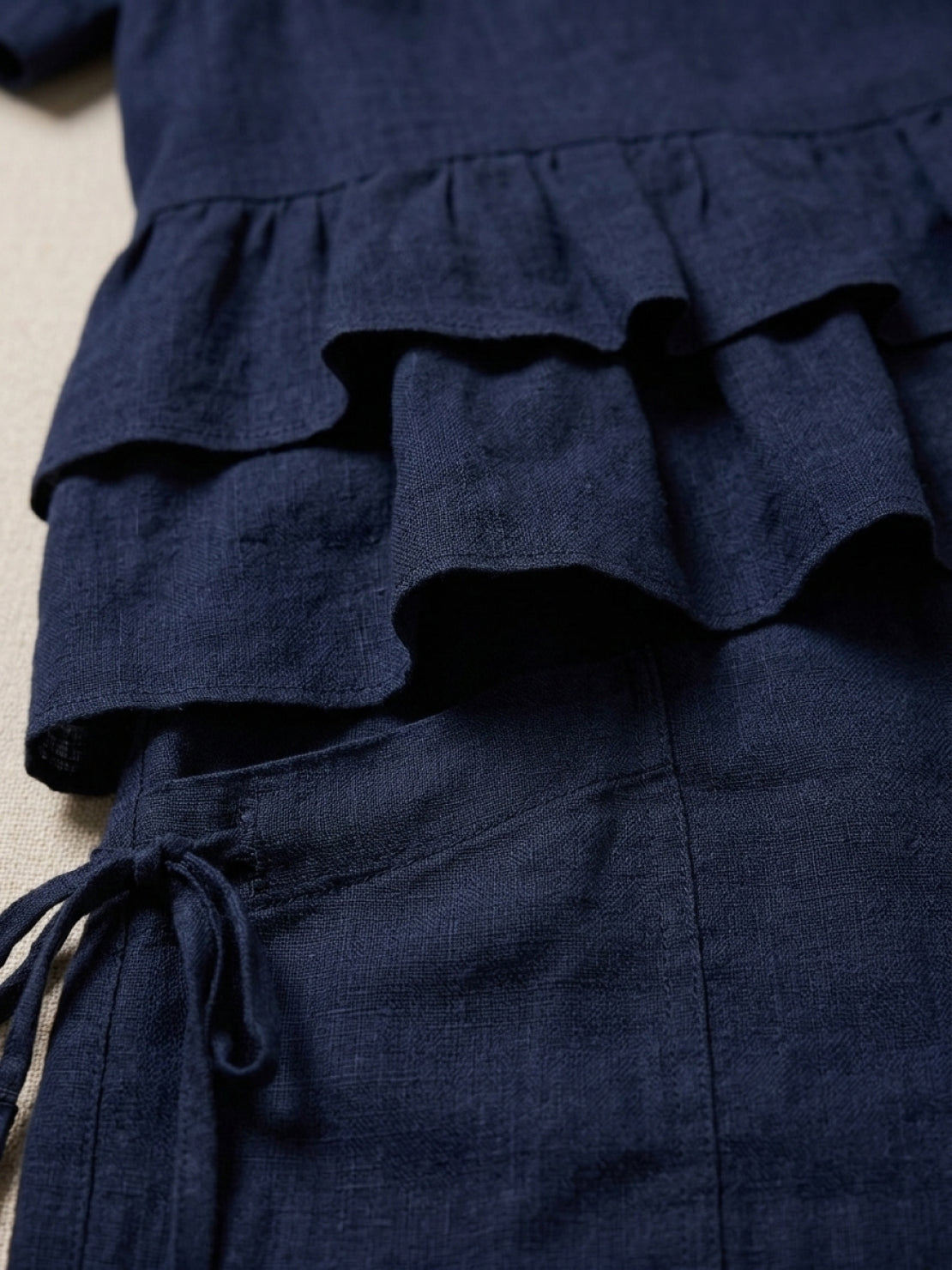 Woman wearing navy blue cotton relaxed shorts two-piece co-ord set with ruffle detail and side pockets