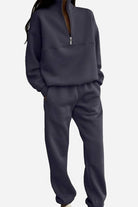 Woman wearing a cotton-blended two-piece tracksuit with high collar and deep zipper in a relaxed silhouette