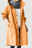 Water Resistant Oversized Windbreaker in orange with hood and button closure worn over casual outfit
