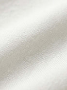 Close-up of soft white cotton fabric texture for short-sleeved pullover and wide trouser matching set